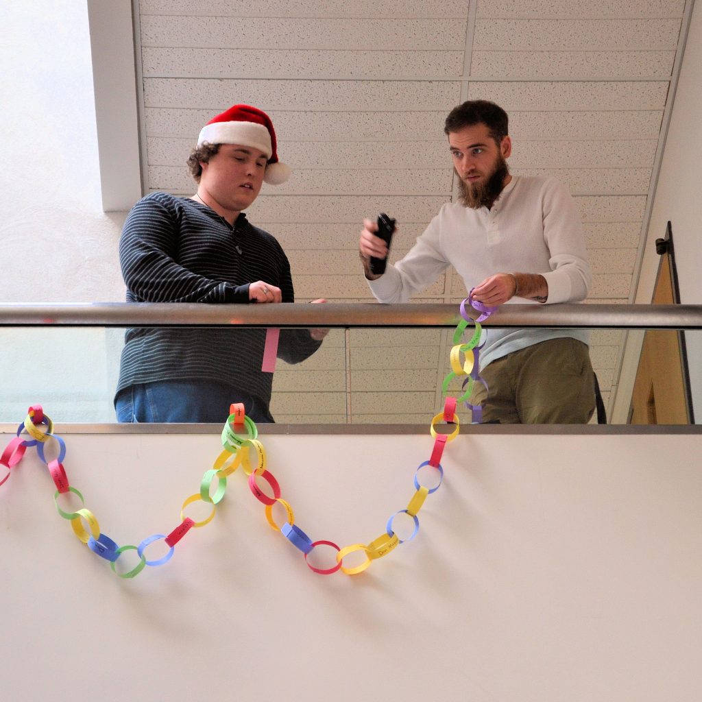 WCC students Jacob Pawvluk (left) and Caleb Grant hang paper-link chain along the stairs in the Atrium of the Wayne Learning Center. Each link signifies a 50 cent donation to the Link Up for the Philippines project.