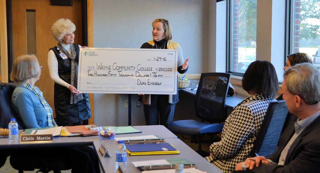 Duke Energy District Manager Millie Chalk presents the WCC Board of Trustees with a $250,000 "check" for new equipment for the college’s Computer-Integrated Machining program.