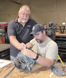 WCC Aviation Systems Technology Director Mark Peeples shows student Shawn Merchant a burr on an aircraft engine cylinder.
