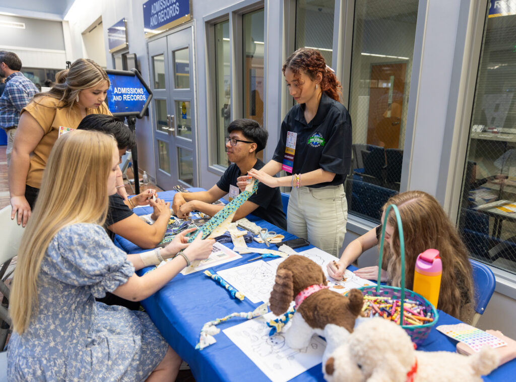 Individuals create animal toys at a table.