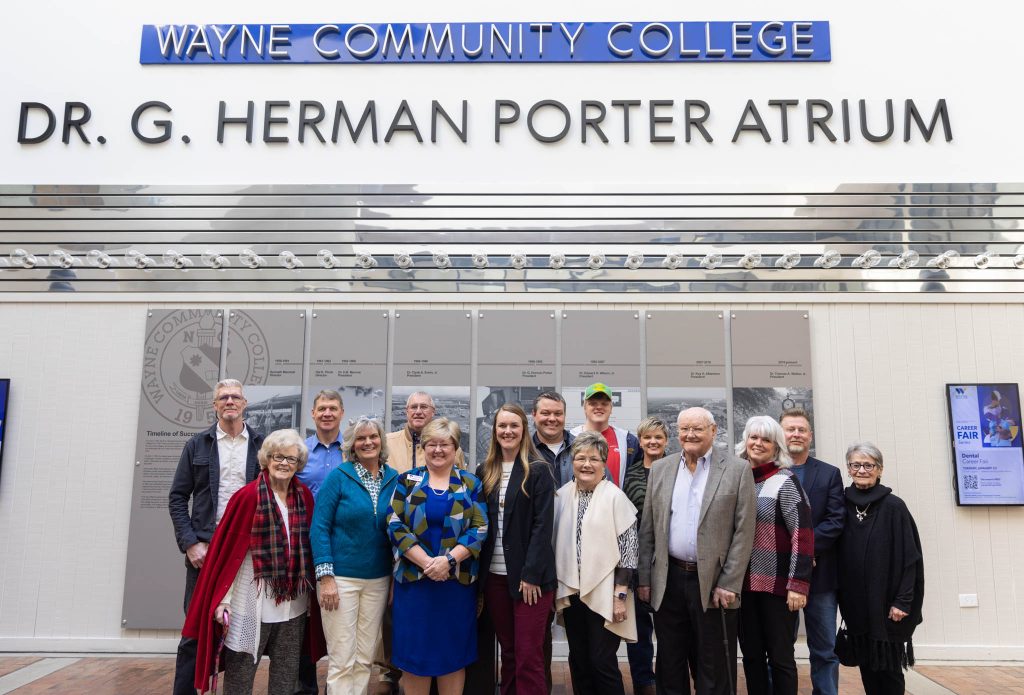 Individuals stand together under a sign.