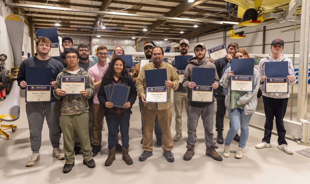 A group of people hold certificates.