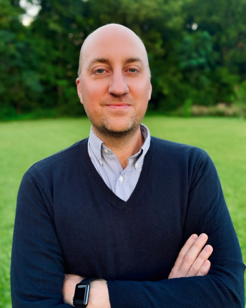 A man stands outside with his arms crossed.