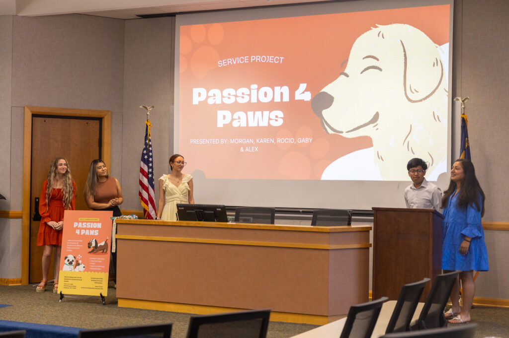 Students stand around a screen showing a dog.