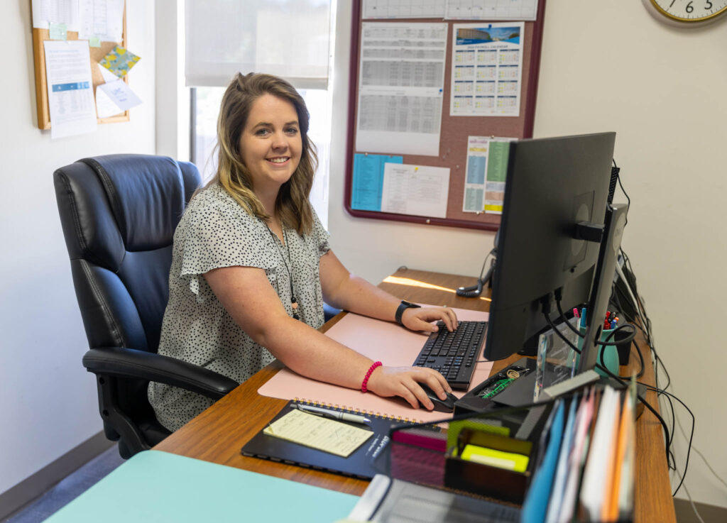 Kelly Lane works on her computer at her desk.