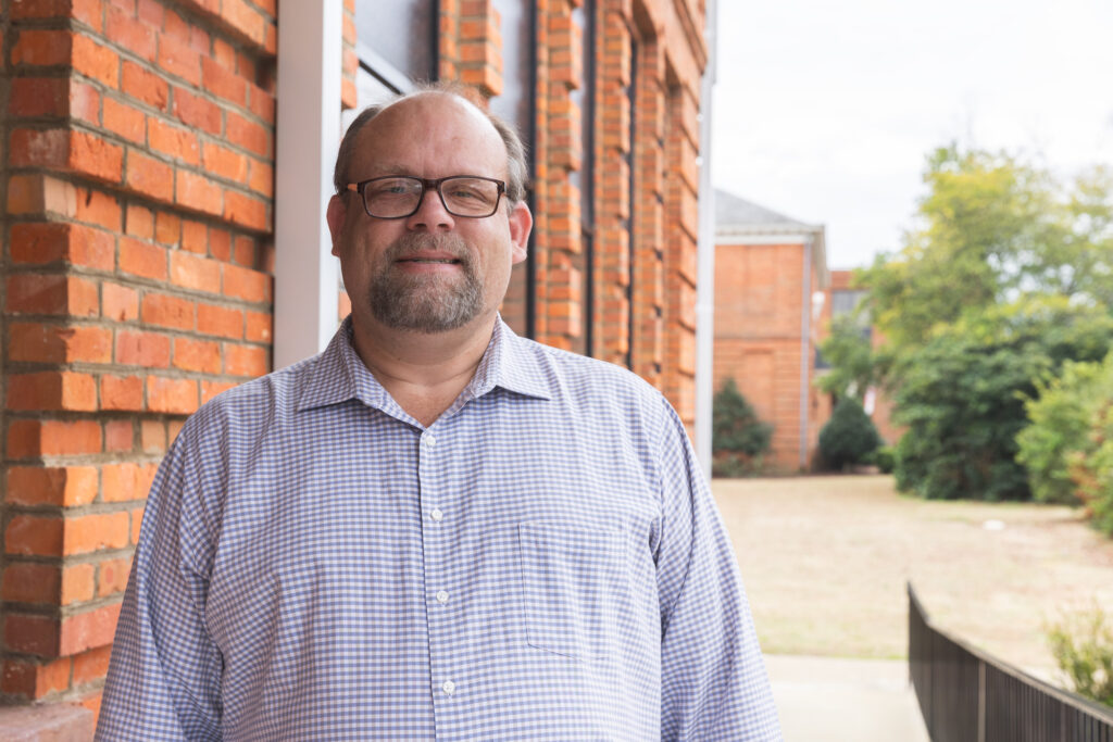 Derek Sparrow stands in front of a building.