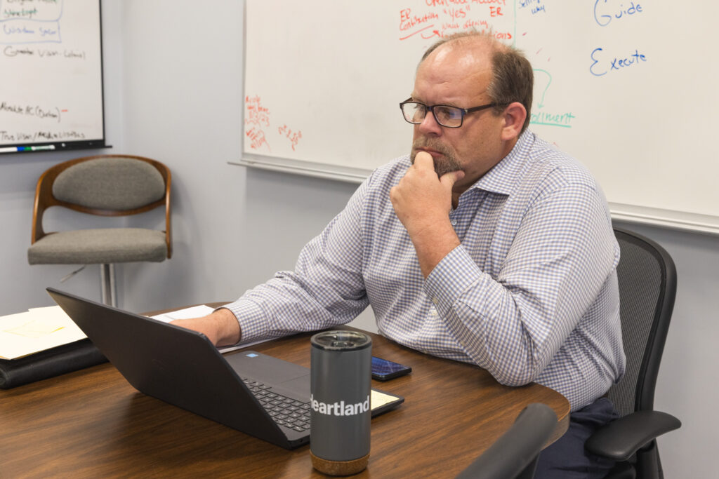 Derek Sparrow works on a laptop computer at his office job.